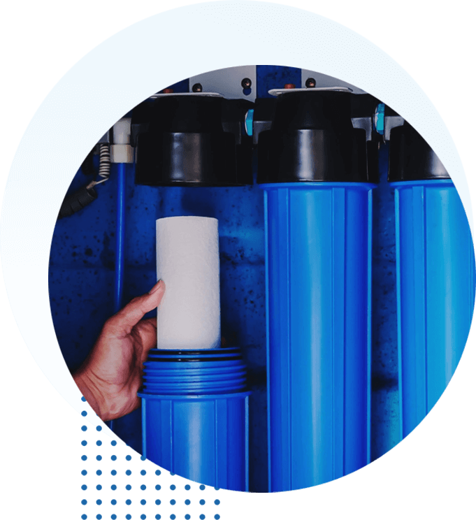 A person holding a paper towel in front of blue water filters.