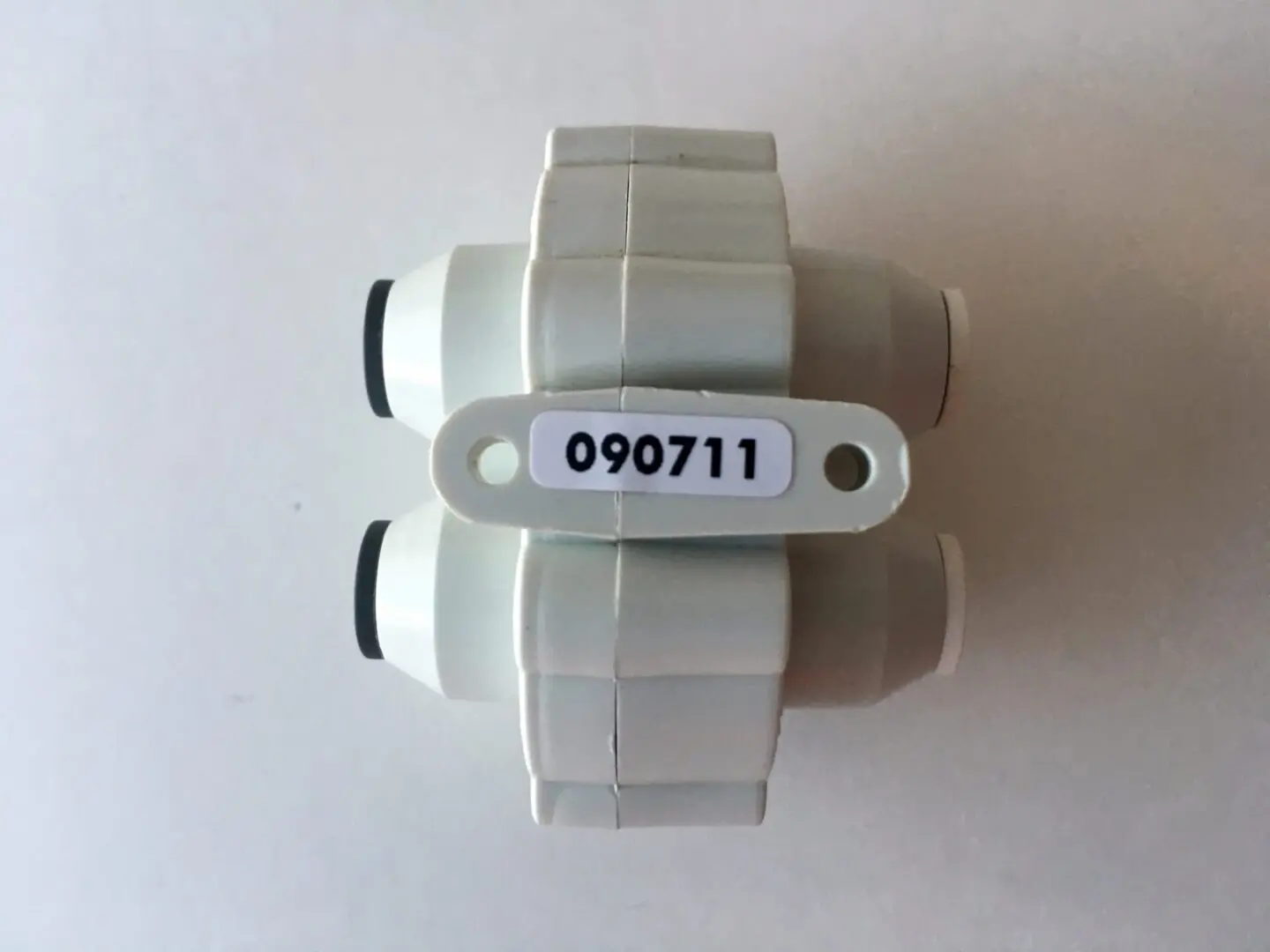 A white plastic object with a number on it.